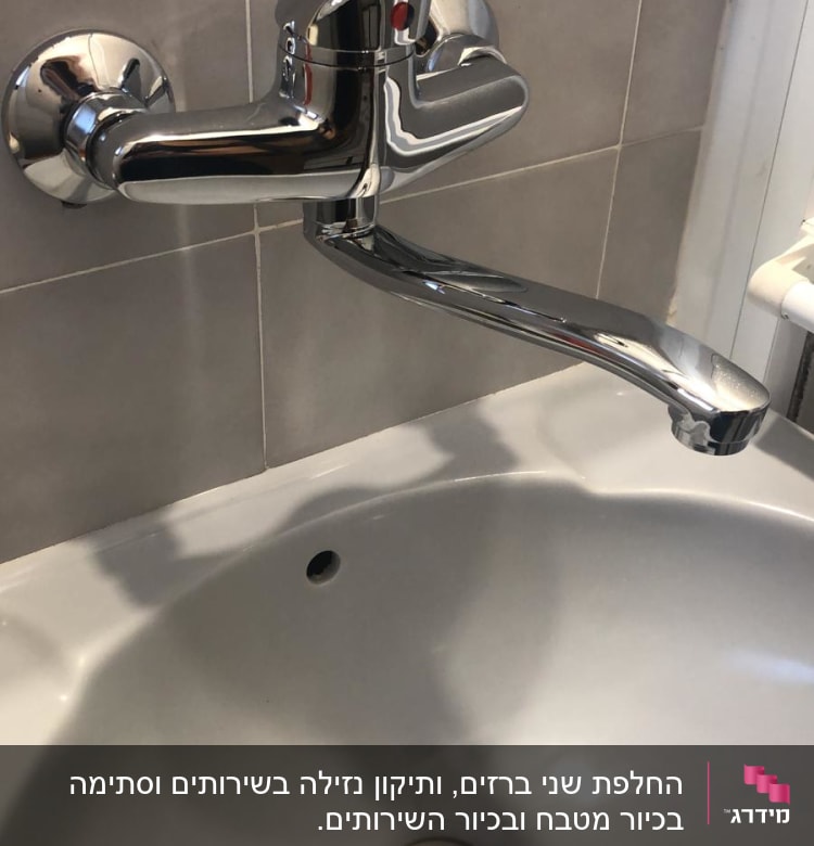 ברז כרום מותקן על קיר מעל כיור לבן